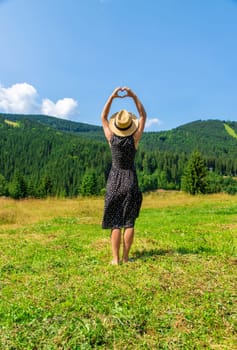 A woman in the mountains admires nature. Selective focus. Nature.