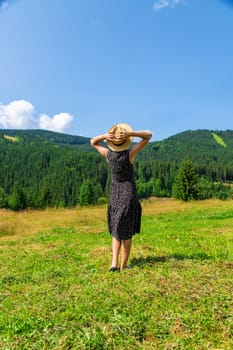 A woman in the mountains admires nature. Selective focus. Nature.