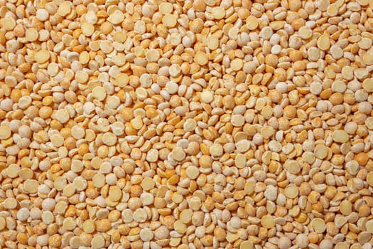 Uncooked Polished Split Peas Background. A Culinary Canvas of Dry Yellow Peas, Creating a Lively and Textured Background for Gourmet Cooking. Scattered Raw Polished Peas. Healthy Eating Ingredients