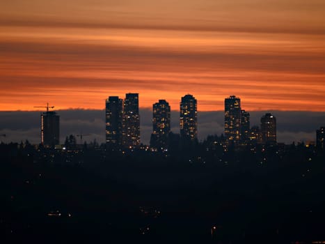 City lights after sunset on darker sky and cumulus clouds background.