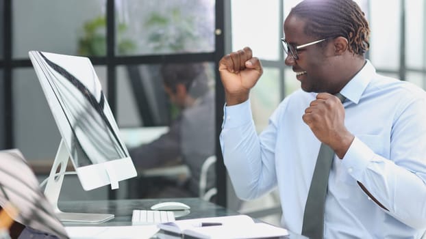 happy man working in the office. raised up his hands joyfully