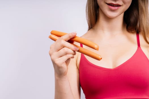 Woman opened her mouth and wants to bite off a sausage, close-up