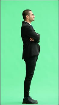 young man in full growth. isolated on green background profile.