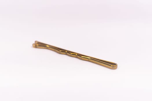 Small gold black metal hairpin isolated on a white background closeup