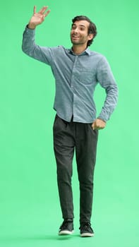 young man in full growth. isolated on green background goes.