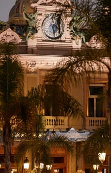 Monaco, Monte-Carlo, 12 November 2022: The famous square of Casino Monte-Carlo is at dusk, attraction night illumination, luxury cars, players, tourists, splashes of fountain. High quality photo