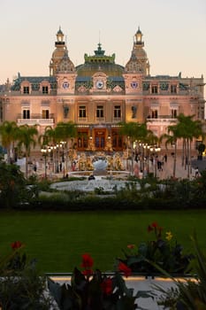 Monaco, Monte-Carlo, 21 October 2022: Square Casino Monte-Carlo at sunny day, a lot of luxury cars, Hotel de Paris, wealth life, tourists take pictures of the landmark, pine trees, blue sky, flowers. High quality 4k footage