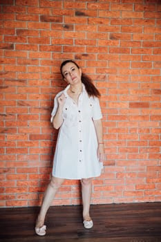 Beautiful brunette woman in summer pink dress smiling