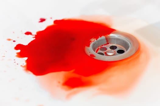 Blood in a white ceramic sink. Bleeding gums or wound of a person. Close-up of an abundance of blood in the bathroom.