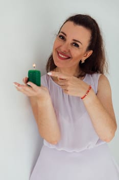 brunette woman holding a green candle in her hands