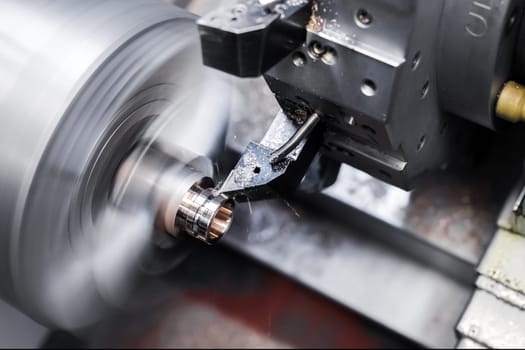 Close-up of turning work on a machine, turning a metal workpiece. Motion blur.