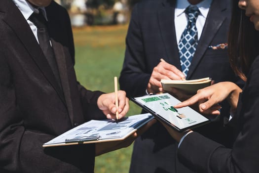 Group of asian business people presenting environmentally friendly development plan and sustainable technology project for greener future, establishing outdoor eco business office at natural park.Gyre