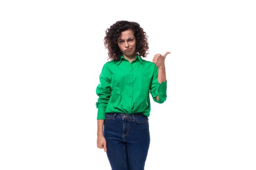 young caucasian lady with black curls is dressed in a green shirt on a white background.