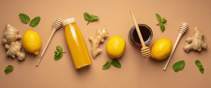Composition with detox drink, lemons, mint, ginger, honey in glass jar, honey wooden dippers top view. Food for immunity stimulation and against flu. Healthy natural remedies to boost immune system.