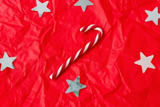 This is a bright and colorful Christmas background with white stars, a candy cane, and a crumpled texture