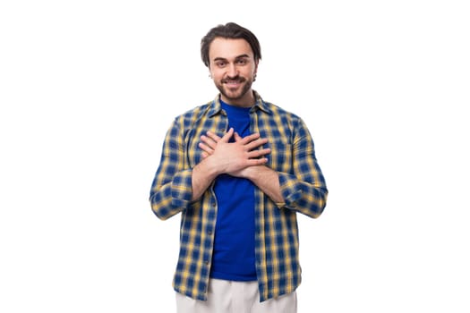 portrait of a pleasant calm young european brunette with a beard dressed stylishly in a shirt.