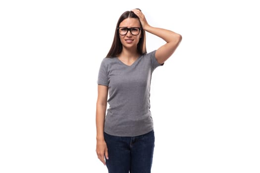 portrait of a caucasian slim young woman in glasses dressed in a gray basic t-shirt and jeans.