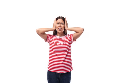 young upset brunette woman in a red striped t-shirt holding her head.