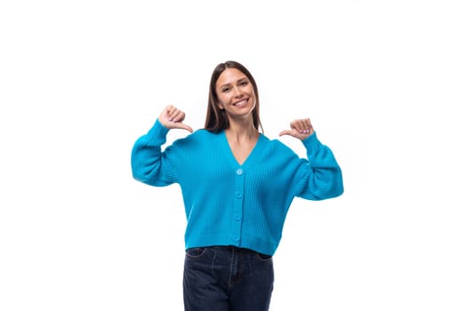 young pretty smiling brunette promoter woman in a blue cardigan actively gesturing with her hands on a white background.