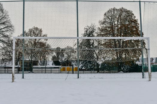 A snow-covered football goal. The concept of the end of the football season, the football league and the end of the sports season.