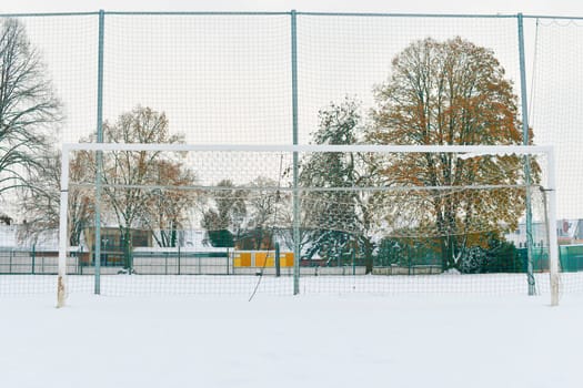 A football goal covered in snow. The concept of the end of the football season and the end of the football league.