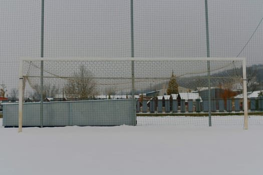 A snow-covered football goal. The concept of the end of the football season, the football league and the end of the sports season.
