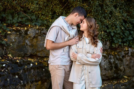 Young Cute Female Hugs Boyfriend. In Autumn Outdoor. Lovers Walking in Park. Attractive Funny Couple. Lovestory in Forest. Man and Woman. Cute Lovers in the Park. Family Concept. Happy Couple.