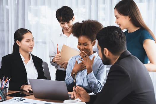 Happy diverse business people work together, discussing in corporate office. Professional and diversity teamwork discuss business plan on desk with laptop. Modern multicultural office worker. Concord