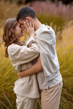 Young Cute Female Hugs Boyfriend. In Autumn Outdoor. Lovers Walking in Park. Attractive Funny Couple. Lovestory in Forest. Man and Woman. Cute Lovers in the Park. Family Concept. Happy Couple.