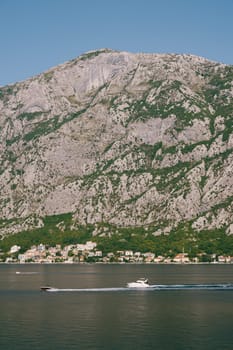 Yachts sail on the blue sea along the mountainous coast. High quality photo