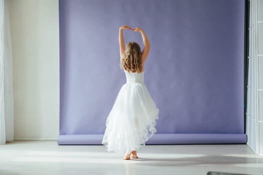 Beautiful girl of 10 years dancing alone in a white dress