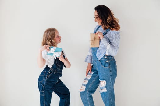 beautiful woman with daughter with gifts in a denim jumpsuit