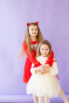 Two beautiful girls in red and white dresses for the holiday