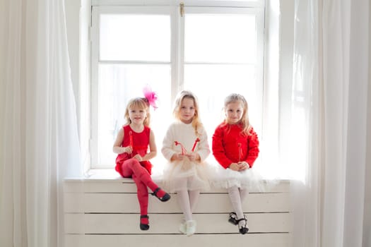 three little girls in red and white dresses at the party