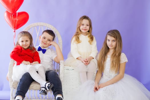 Boy and girls with red heart-shaped balloons on birthday