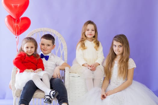 Boy and girls with red heart-shaped balloons on birthday