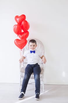 Boy with red heart-shaped balloons on birthday
