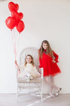 Girls with red heart-shaped balloons on birthday