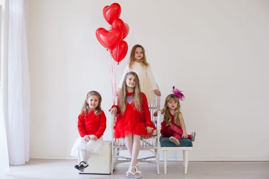 Girls with red heart-shaped balloons on birthday