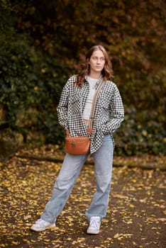 Autumn Elegance: Girl with Warm Tones, Casual Style, and a Park Stroll. ashion trends, autumn style, casual elegance, outdoor fashion, trendy accessories, park lifestyle, cozy vibes, seasonal warmth, stylish look, autumnal hues