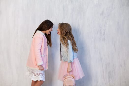 Two beautiful fashionable girl girlfriends in white pink poatya