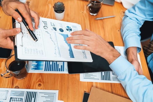 Top view diverse group of business analyst team analyzing financial data report paper on meeting table. Chart and graph dashboard by business intelligence analysis. Habiliment