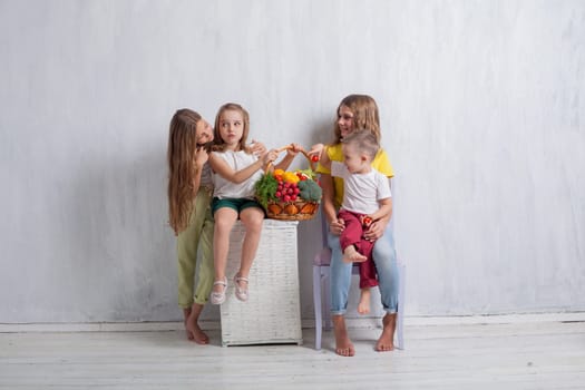 three girls and a boy with a meal of ripe vegetables and fruits