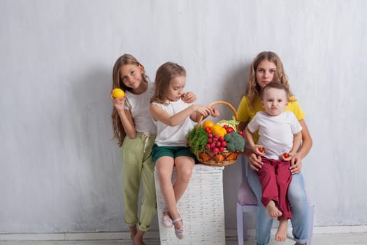 three girls and a boy with a meal of ripe vegetables and fruits