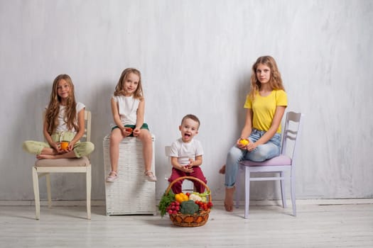 three girls and a boy with a meal of ripe vegetables and fruits