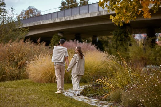 Young Cute Female Hugs Boyfriend. In Autumn Outdoor. Lovers Walking in Park. Attractive Funny Couple. Lovestory in Forest. Man and Woman. Cute Lovers in the Park. Family Concept. Happy Couple.