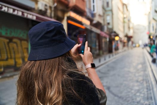 ISTANBUL, TURKEY - 08.05.2021: Young woman photographs the sights of Istanbul on her phone. High quality photo