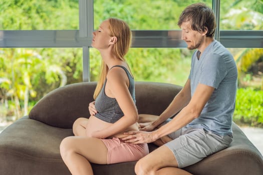 health, pregnancy and happy people concept - husband giving his wife back massage at home.