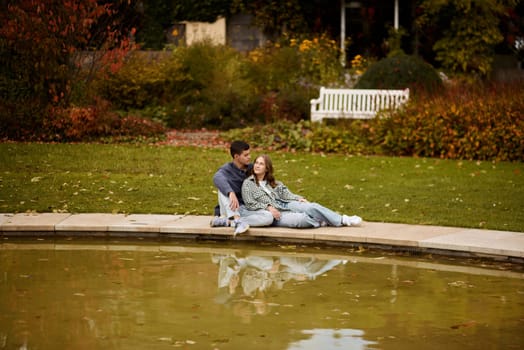 lovely young couple kissing outdoors in autumn. Loving couple walking in nature. Autumn mood. Happy man and woman hugging and kissing in autumn. Love. Fashionable couple outdoors. Fashion, people and lifestyle. Stylish couple in autumn outfit.