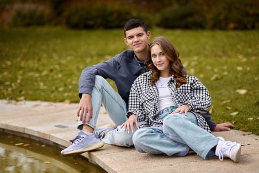 lovely young couple kissing outdoors in autumn. Loving couple walking in nature. Autumn mood. Happy man and woman hugging and kissing in autumn. Love. Fashionable couple outdoors. Fashion, people and lifestyle. Stylish couple in autumn outfit.